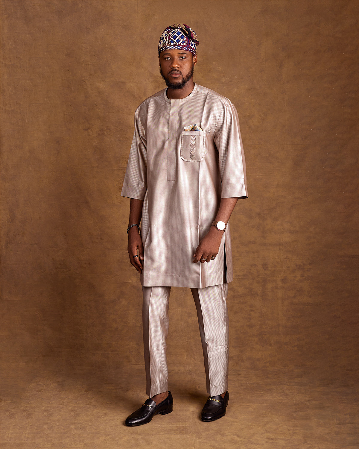 Man wearing senator wear with Yoruba cap in the right direction 